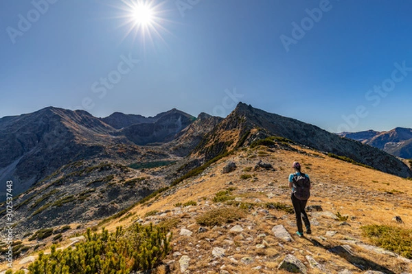 Fototapeta Woman hiking in Rila mountains on the way to Musala peak in Bulgaria on a sunny day in Autumn, Fall