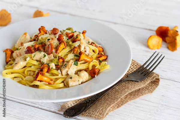 Fototapeta Tagliatelle with fried fresh chanterelles and chicken.
