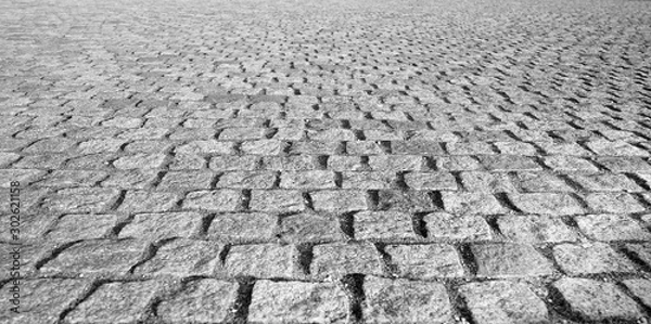 Fototapeta Perspective View Monotone Gray Brick Stone Pavement on The Ground for Street Road. Sidewalk, Driveway, Pavers, Pavement in Vintage Design Ground Flooring Square Pattern Texture Background