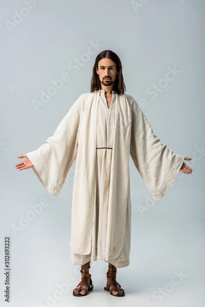 Fototapeta religious man in jesus robe standing with outstretched hands on grey