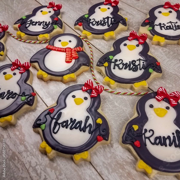 Fototapeta Collection of boy and girl personalized Christmas penguins as decorated sugar cookies for gifts with generic names written in frosting