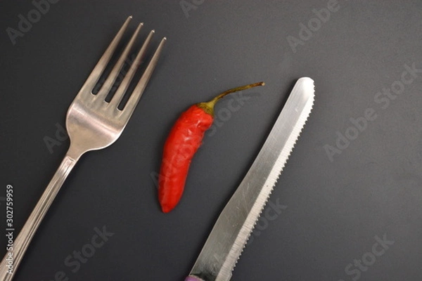 Fototapeta peperoncino rosso piccante ingrediente per cucinare su tavolo con forchetta e coltello di metallo