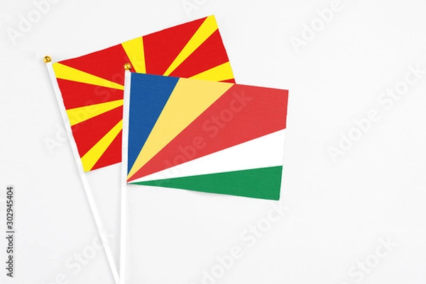 Fototapeta Seychelles and Macedonia stick flags on white background. High quality fabric, miniature national flag. Peaceful global concept.White floor for copy space.