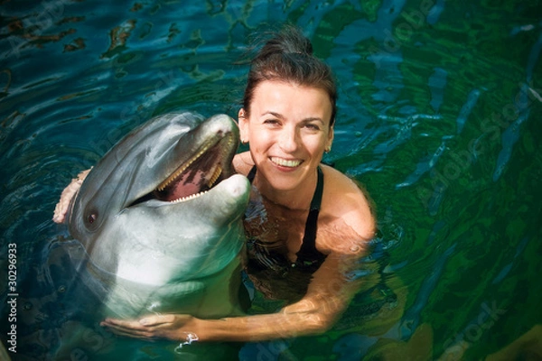 Obraz Dziewczyna ściska delfinu w wodzie