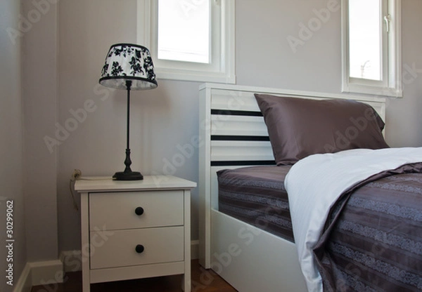 Obraz Bed with gray sheet and lamp on head