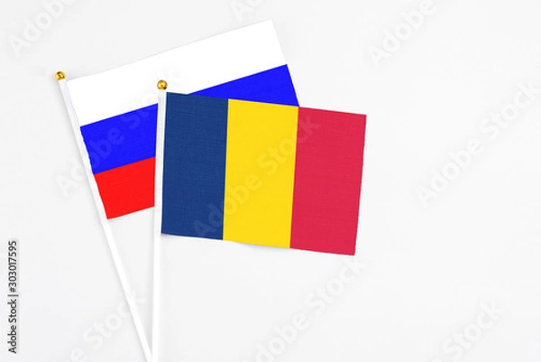 Fototapeta Chad and Russia stick flags on white background. High quality fabric, miniature national flag. Peaceful global concept.White floor for copy space.