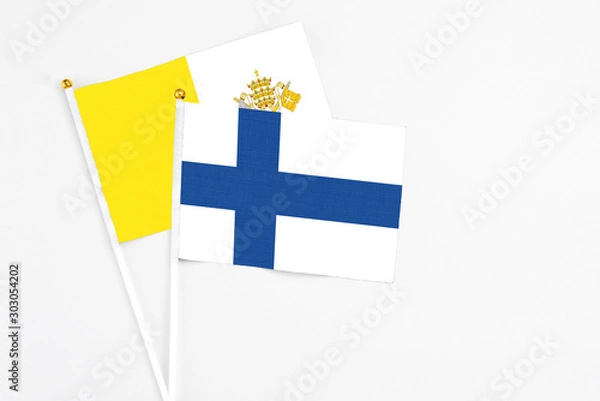 Fototapeta Finland and Vatican City stick flags on white background. High quality fabric, miniature national flag. Peaceful global concept.White floor for copy space.