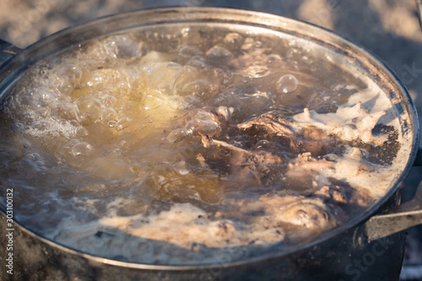 Fototapeta boiling duck in a pan on a fire