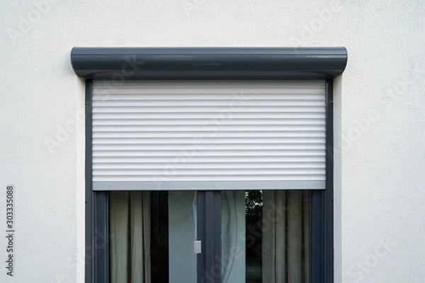Obraz Light roller shutter curtains mounted on a dark window