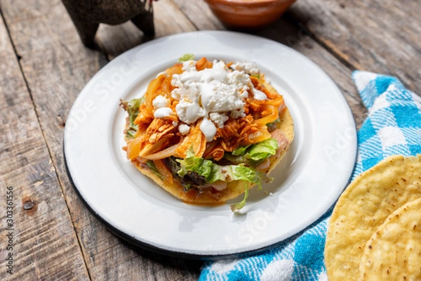 Fototapeta Mexican chicken tinga toasts with chipotle pepper and fresh cheese also called "tostadas" on wooden background