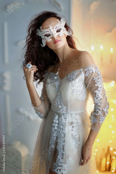 Obraz New year photo of a model girl in a white dress on a background of a yellow bright new year tree.