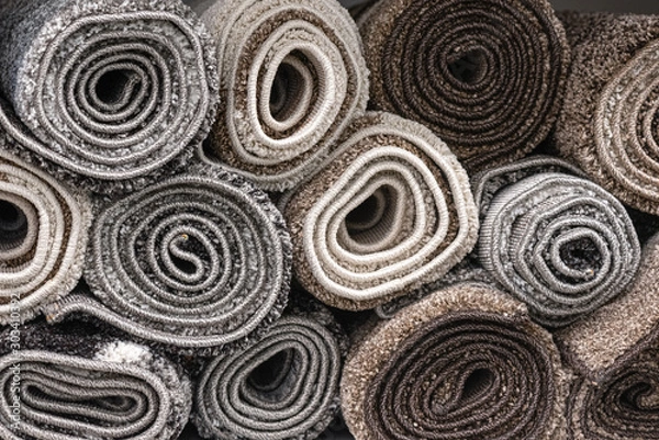 Fototapeta Rolled carpets on a store counter close up abstract background.