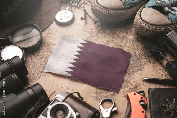 Fototapeta Qatar Flag Between Traveler's Accessories on Old Vintage Map. Tourist Destination Concept.