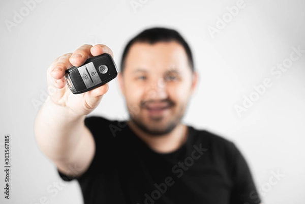 Fototapeta Satisfied man shows keychain from the car