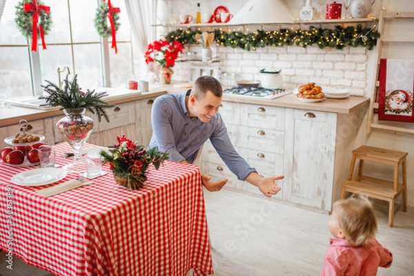 Fototapeta little daughter running to the father on the kitchen