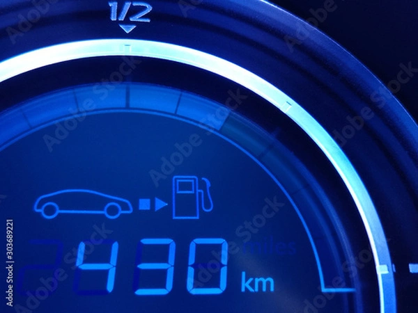 Obraz Fuel economy gauge with glowing digital technology indication of mileage remaining to refueling. Close-up fragment of car dashboard. Conceptual photo of energy saving, climate and environment issues.