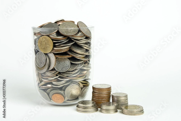 Obraz A coin in a glass jar isolated on white background. Saving for the future. Close up shot.