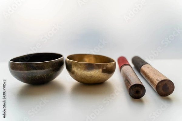 Fototapeta Bronze singing bowls with clappers on white background for meditation or massage (shallow depth of field)