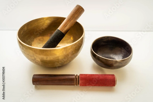 Fototapeta Bronze singing bowls with clappers on white background for meditation or massage (shallow depth of field)