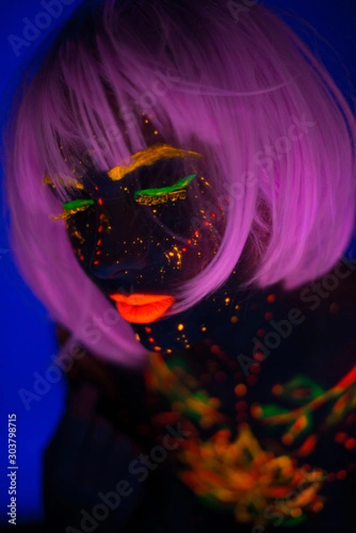 Fototapeta Portrait of Beautiful Fashion Woman in Neon UF Light. Model Girl with Fluorescent Creative Psychedelic MakeUp, Art Design of Female Disco Dancer Model in UV, Colorful Abstract Make-Up. Dancing Lady