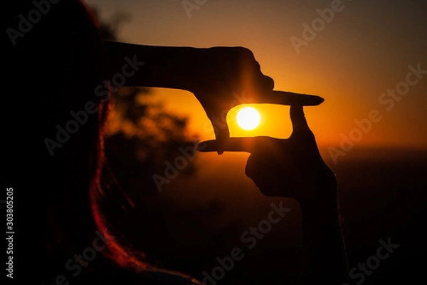 Obraz hands folded in a frame on a sunset background
