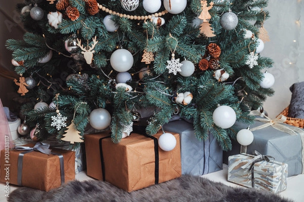 Fototapeta Gift boxes Packed in Kraft paper lie under the Christmas tree