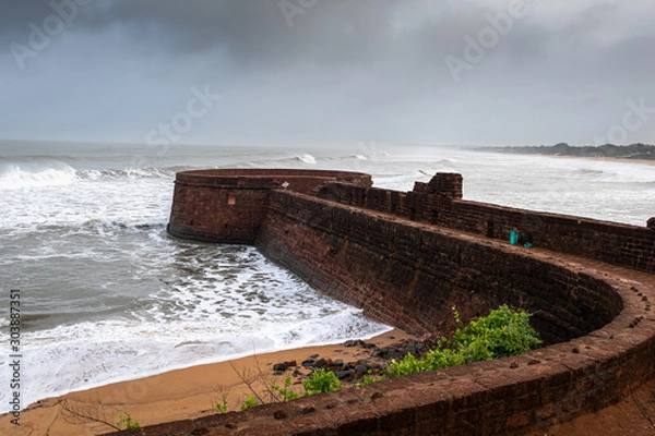 Fototapeta Old ruins of Fort Aguada on the seashores of Goa with sky and clouds