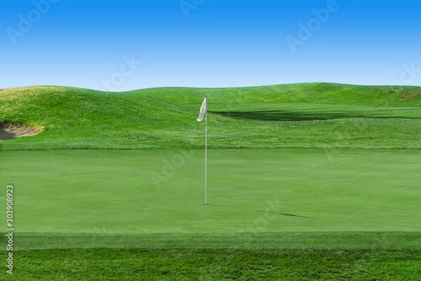 Fototapeta White flag on a golf course with blue sky