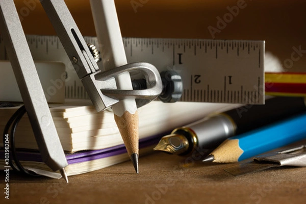 Fototapeta Compass for drawing and stationary on wooden table. Concept of architecture office or back to school. Closeup and copy space for text.