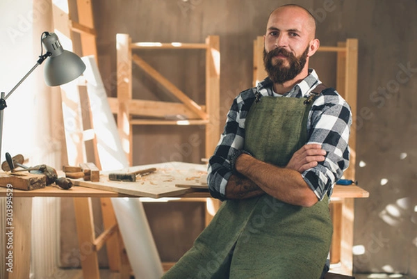 Fototapeta Portrait of a young male carpenter who works in his workshop.