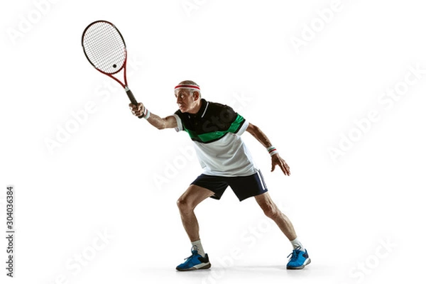 Fototapeta Senior man wearing sportwear playing tennis isolated on white background. Caucasian male model in great shape stays active and sportive. Concept of sport, activity, movement, wellbeing. Copyspace, ad.