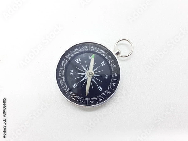 Fototapeta Useful Metallic Dark Needle Magnetic Hand Compass to Show Direction when Camping or Travelling Concept in White Isolated Background