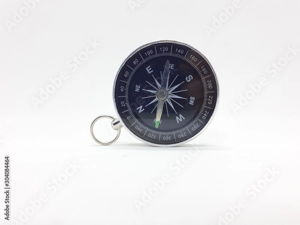 Fototapeta Useful Metallic Dark Needle Magnetic Hand Compass to Show Direction when Camping or Travelling Concept in White Isolated Background