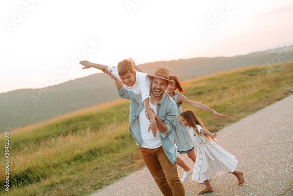 Fototapeta Happy smiling family spending summer day at park.