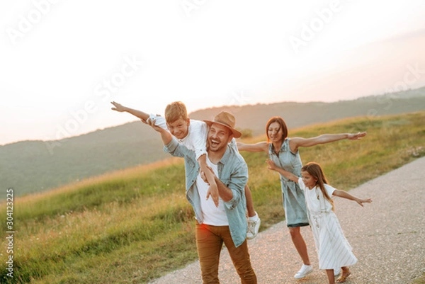 Fototapeta Happy smiling family spending summer day at park.
