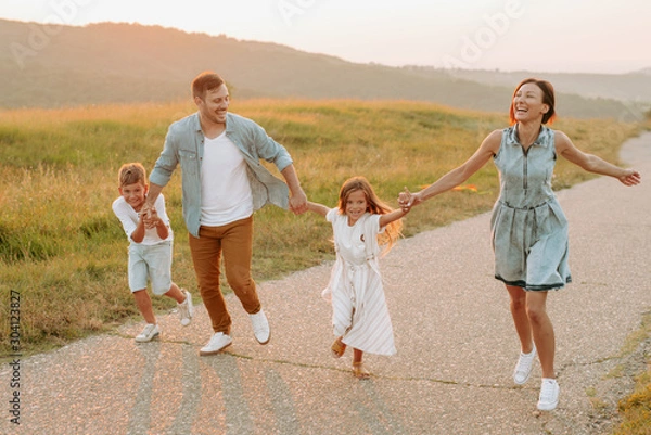 Fototapeta Happy smiling family spending summer day at park.