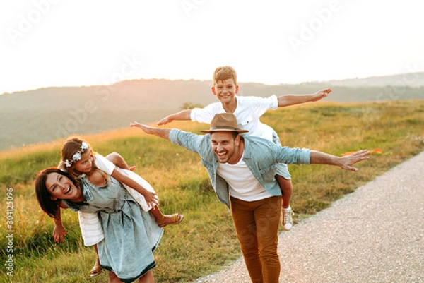 Fototapeta Happy smiling family spending summer day at park.Happy smiling family spending summer day at park.