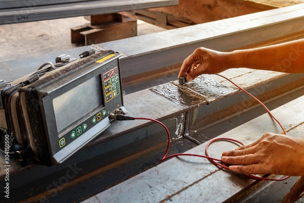 Fototapeta Checking defect in welded of steel add joint with process Ultrasonic testing (UT) of Non-Destructive Testing(NDT), focus on hand that conducts the welding test.