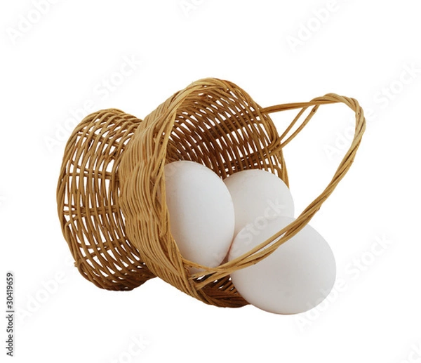 Obraz three white eggs spilled from straw interwoven basket