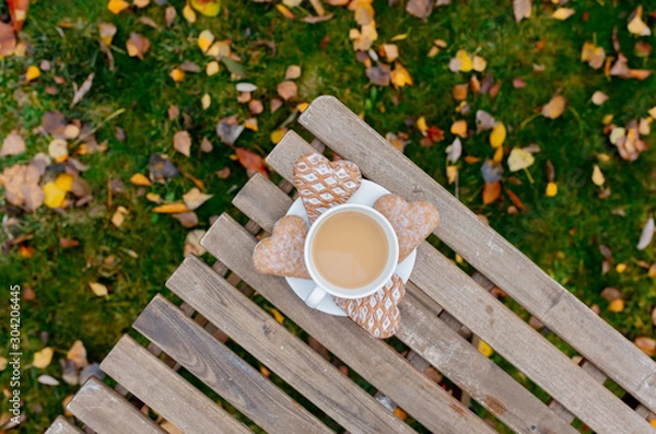 Fototapeta Cup of coffee with heart shape cookies on a table i