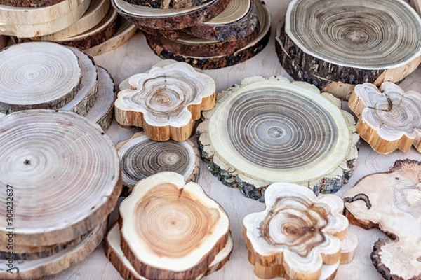 Fototapeta Wooden hot stands made from tree trunk slices on the counter. Kitchenware from natural materials. Selective focus, close-up