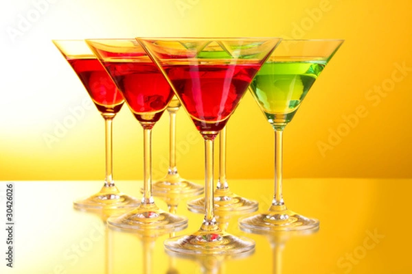 Fototapeta a few glasses of alcoholic drinks in a yellow-brown background
