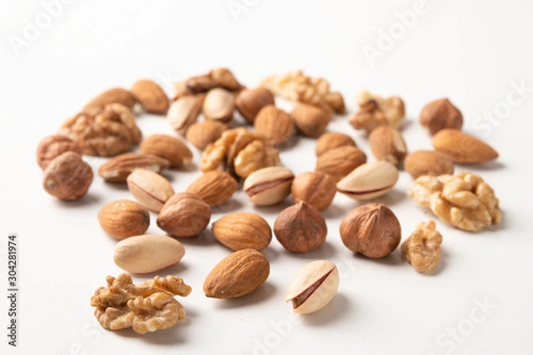 Fototapeta Mixed nuts on a white surface