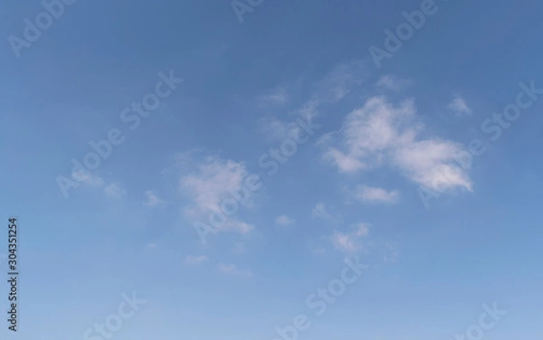 Fototapeta abstract cloudscape of small wispy puffy clouds in a clear blue sky with a little haze at the bottom