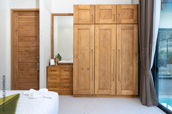 Fototapeta spacious and modern bedroom with wooden wardrobe