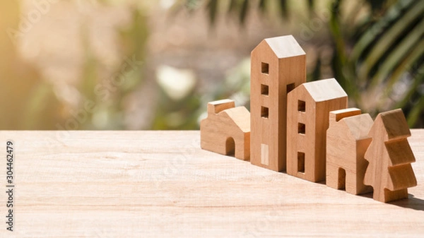 Obraz Model of wooden houses ,apartment and tree on wooden table and natural background, Image for community or real estate business investment advertisement concept,