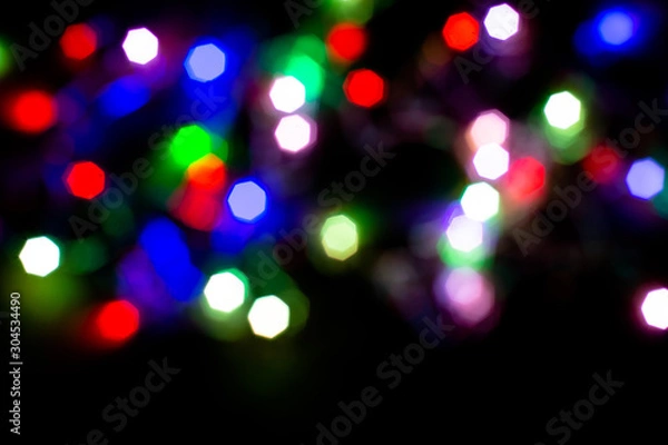 Fototapeta Christmas lights are lit on a black background. Copy the area for the top view text.