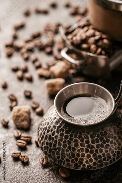 Obraz Coffee cup and coffee beans on dark stone background.