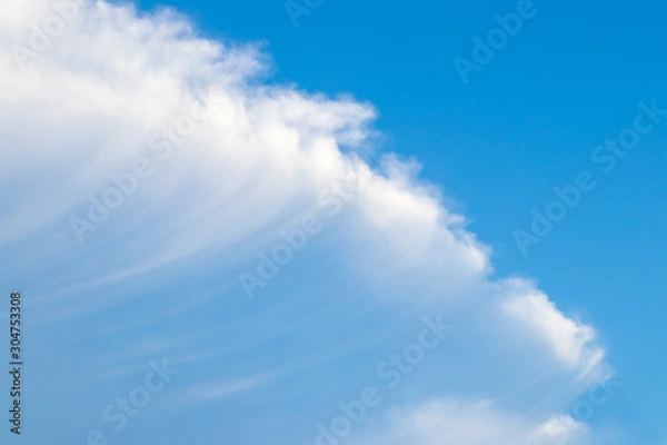 Fototapeta The sky is bright and the clouds are arranged in a diagonal direction, like waves intersecting with the sky. During the daytime.