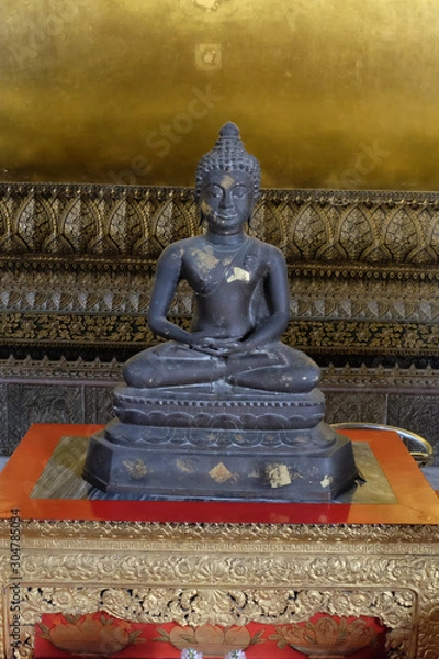 Fototapeta Ancient stone statue of Buddha sitting in lotus position.